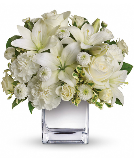 White roses, lilies and other favorites are displayed in a clear cube.