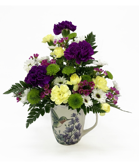 green, purple, and yellow flowers in mug